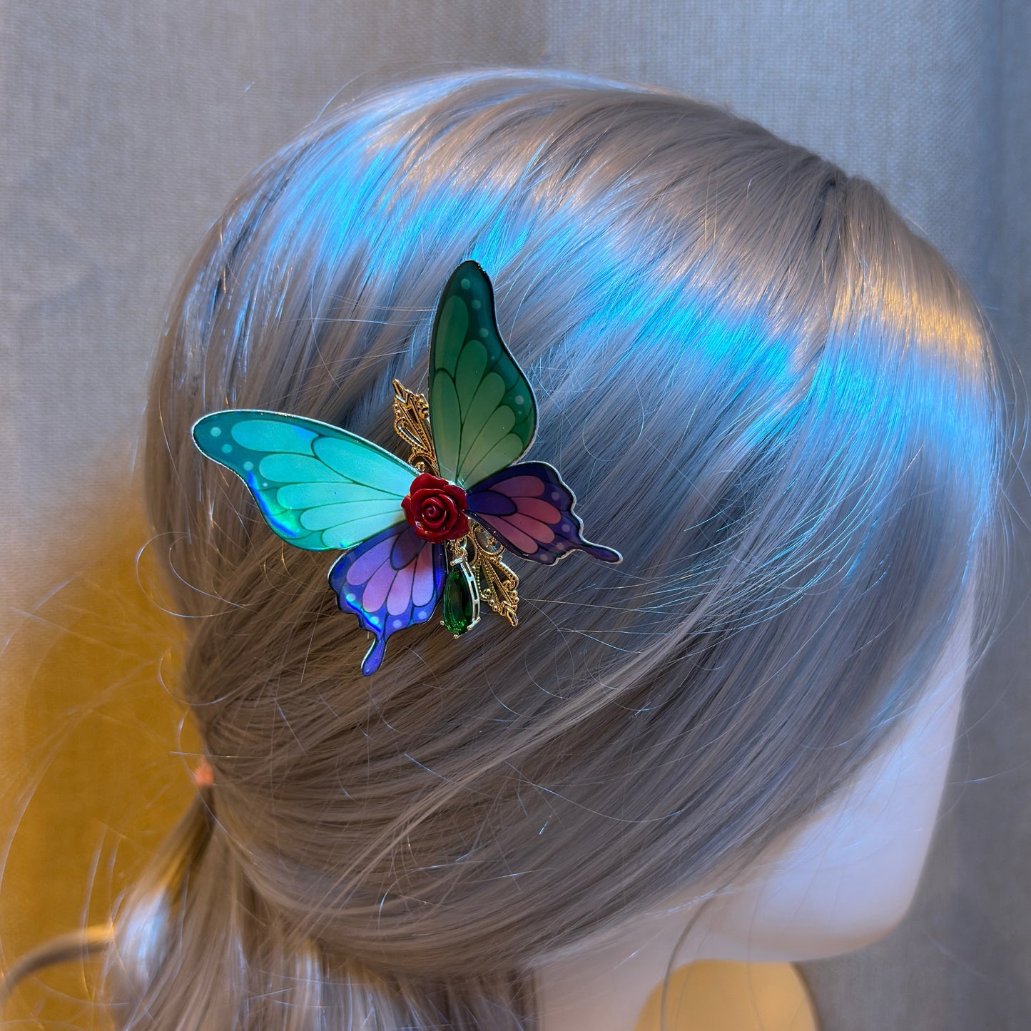 Butterfly hair clip on a mannequin head with blonde hair against a neutral background